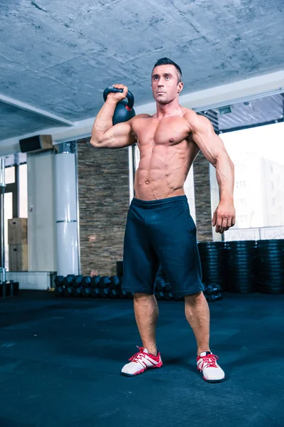 Bodybuilder workout with kettle ball in crossfit gym — Stock Photo, Image