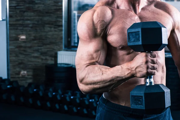 Gespierde man training met dumbbell — Stockfoto