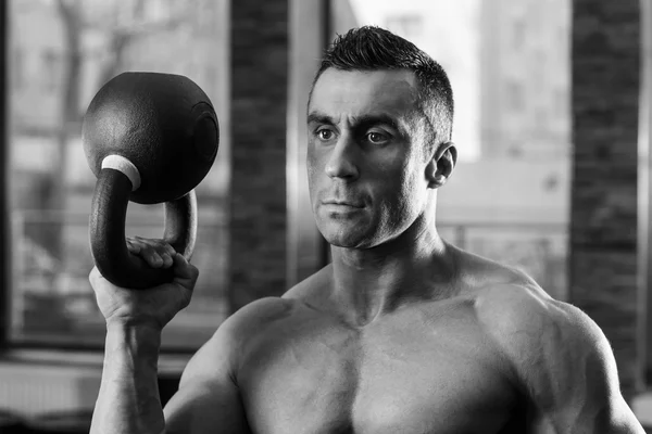 Svartvita porträtt av en bodybuilder holding kettle ball — Stockfoto