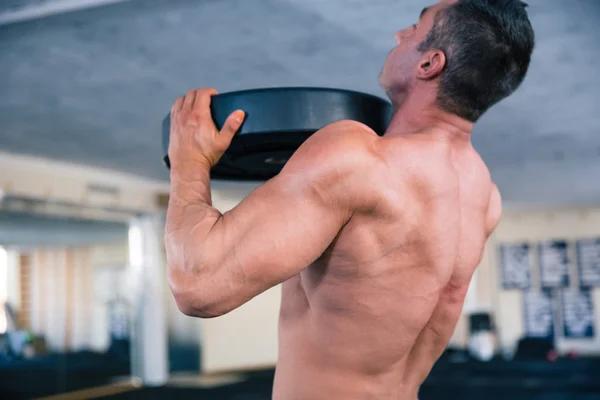 Bodybuilder lifting weight — Stock Photo, Image