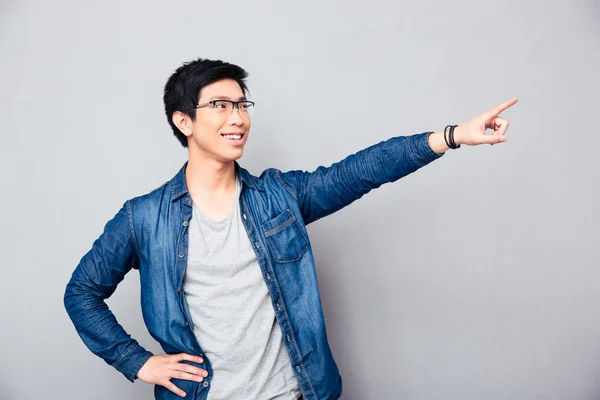 Счастливый азиатский мужчина показывает пальцем прочь — стоковое фото