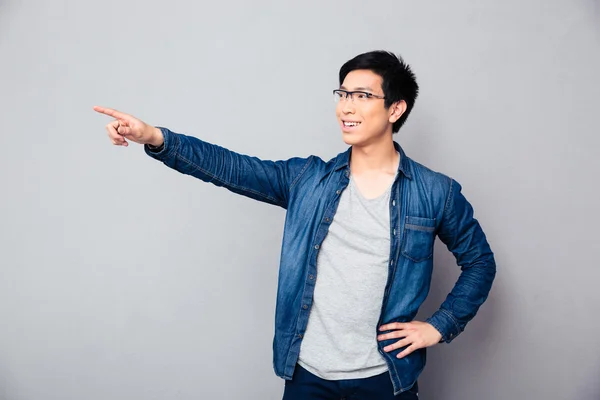 Smiling asian man showing finger away — Stock Photo, Image