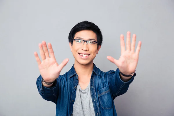 Happy asian man in glasses making stop gesture — Stock Photo, Image