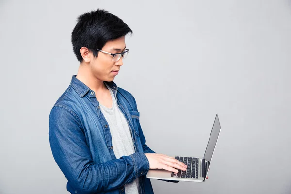 Bello asiatico uomo utilizzando laptop — Foto Stock