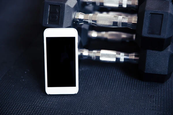 Smartphone con pantalla en blanco en el gimnasio —  Fotos de Stock