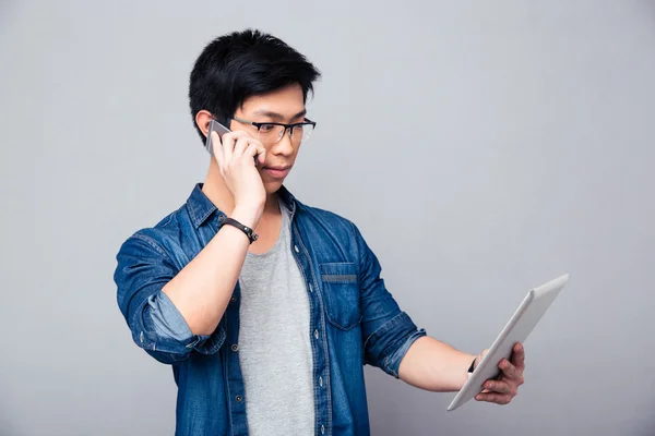 Muž mluví po telefonu a při pohledu na tabletovém počítači — Stock fotografie