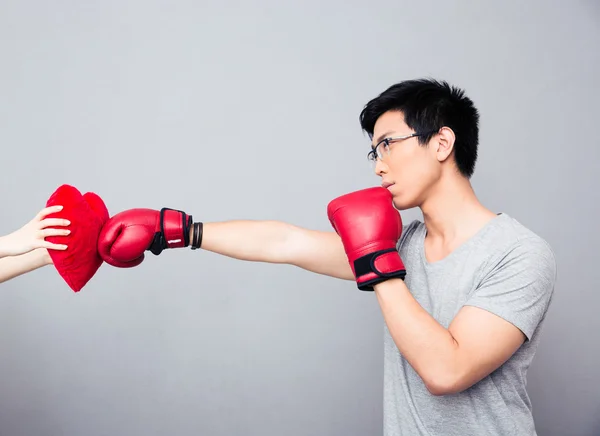 Concept image of a man in boxing gloves hitting at heart — Stock Photo, Image