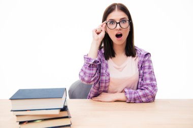 Kitaplar ile masada oturan sürpriz kadın