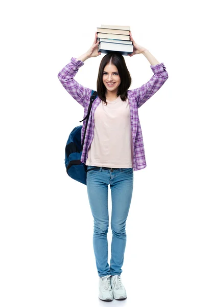 Sonriendo joven wowan sosteniendo libros en la cabeza — Foto de Stock