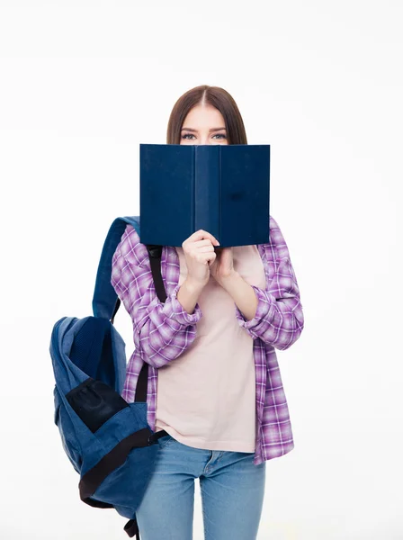 若い女子学生の本で顔を覆っています。 — ストック写真