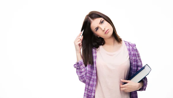 Thoughtful young female student standing with book — Stock Photo, Image