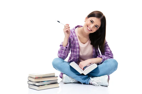 Mulher sorridente sentada no chão com livros — Fotografia de Stock