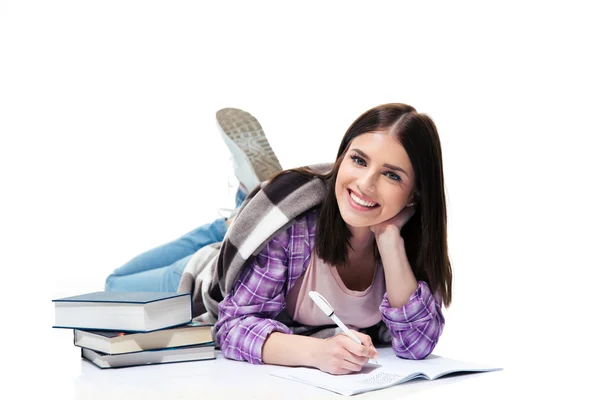 Cheerful woman lying on the floor and writing in notebook — Stock Photo, Image