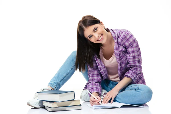 Mujer feliz sentada en el suelo y escribiendo en un cuaderno —  Fotos de Stock