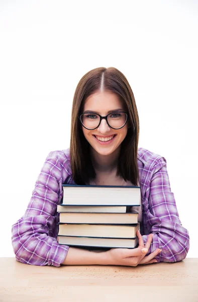 Весела молода жінка сидить за столом з книгами — стокове фото