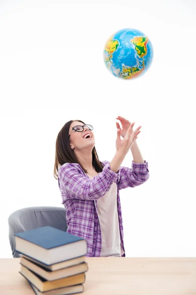 Rindo estudante do sexo feminino jogando globo no ar — Fotografia de Stock
