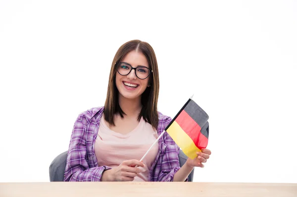 年轻女子坐在桌前与德国国旗 — 图库照片