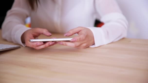 Handen met behulp van smartphone op tafel — Stockvideo