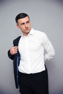 İşadamı soyunma ceket gri arka plan üzerinde