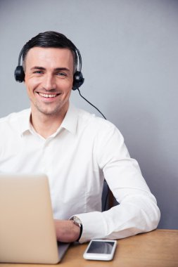 Laptop ve kulaklık ile gülümseyen iş adamı