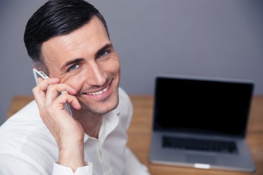 telefonda konuşurken gülümseyen iş adamı 