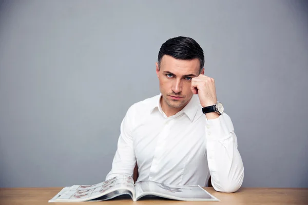 Serious businessman sitting at the table — Stock Photo, Image