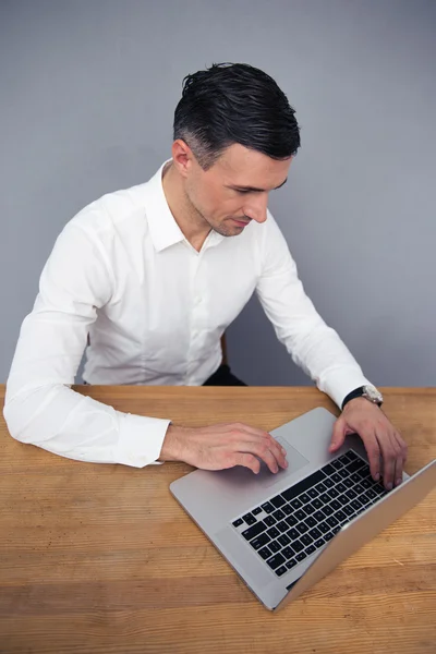 Zakenman zitten aan de tafel en met behulp van laptop — Stockfoto