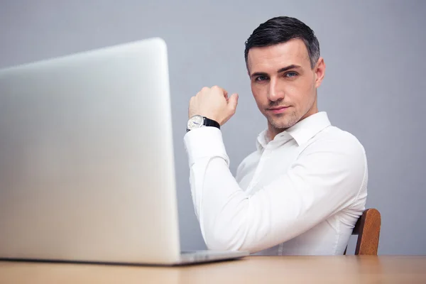 Geschäftsmann sitzt mit Laptop am Tisch — Stockfoto