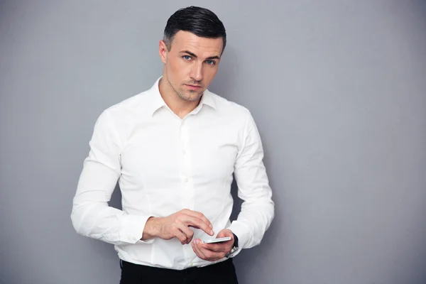 Hombre de negocios serio usando teléfono inteligente — Foto de Stock