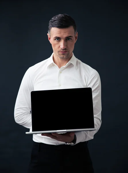 Businessman showing blank laptop screen — Stock Photo, Image