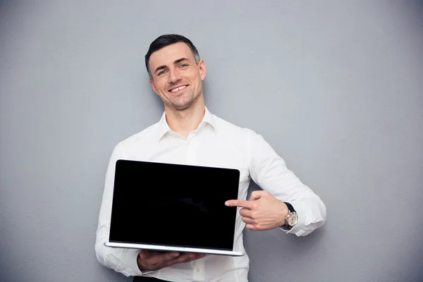 Uśmiechający się biznesmen wskazując palcem na ekranie laptopa puste — Zdjęcie stockowe