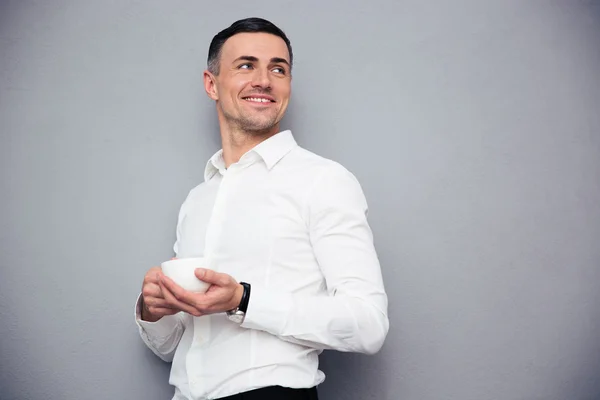 Happy young businessman holding cup of coffee — Stock Photo, Image