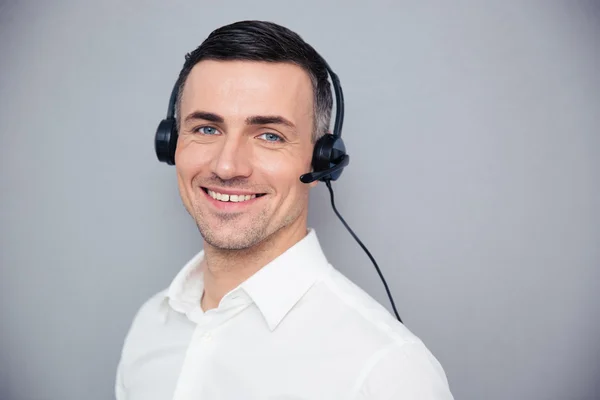 Sonriente operador masculino joven en auriculares — Foto de Stock