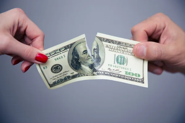 Imagen conceptual de una mano femenina y masculina dividiendo el dinero — Foto de Stock