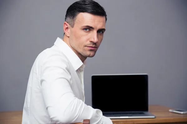 Businessman sitting at thet able with blank laptop screen — Stock Photo, Image