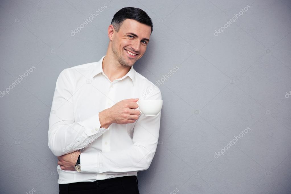 Smiling businessman holding cup of coffee
