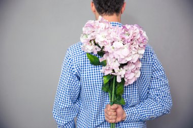 Çiçeklerle duran bir adam portresi arkadan görünüm