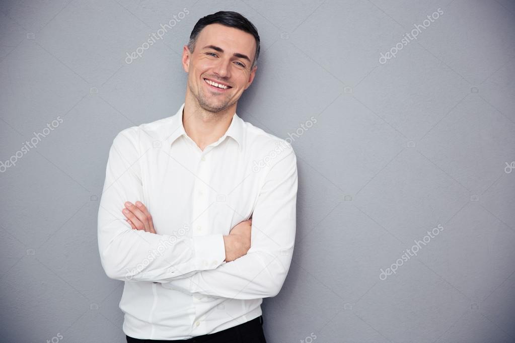 Smiling businessman standing with arms folded