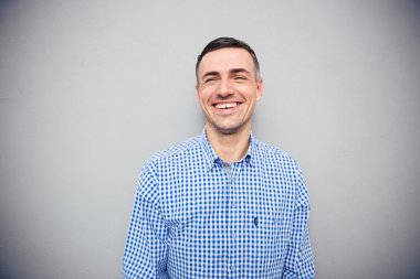 Gri arka plan üzerine gülen bir adam portresi