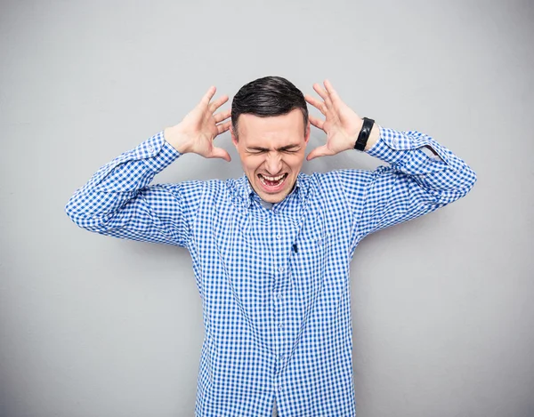 Hombre gritando sobre fondo gris — Foto de Stock