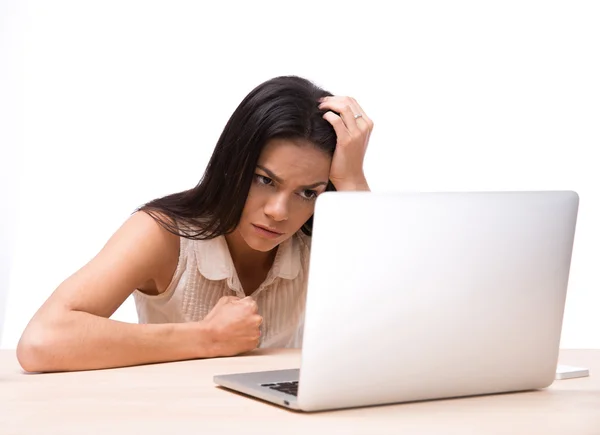 Mujer enojada sentada a la mesa con portátil — Foto de Stock