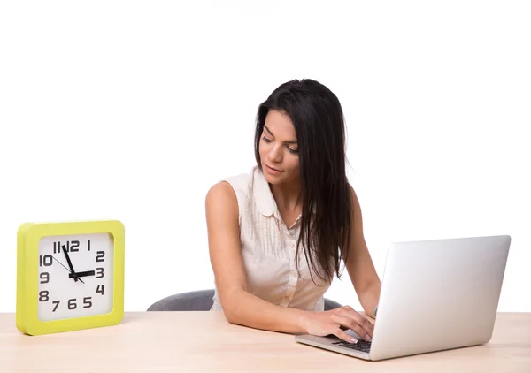 Empresária usando laptop e olhando no relógio — Fotografia de Stock
