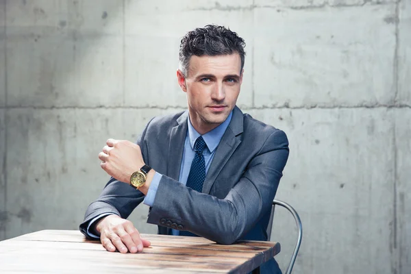 Hombre de negocios guapo sentado a la mesa —  Fotos de Stock