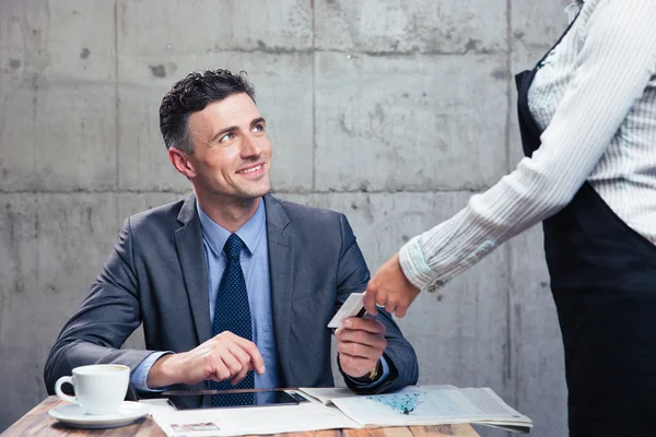 Man giving bank card to female waiter — Stock Photo, Image