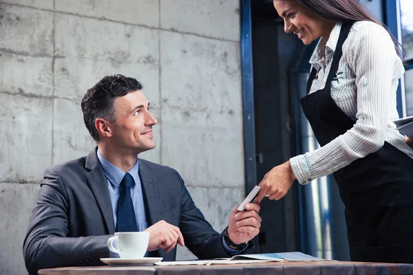 Man giving bank card to female waiter — Stock Photo, Image