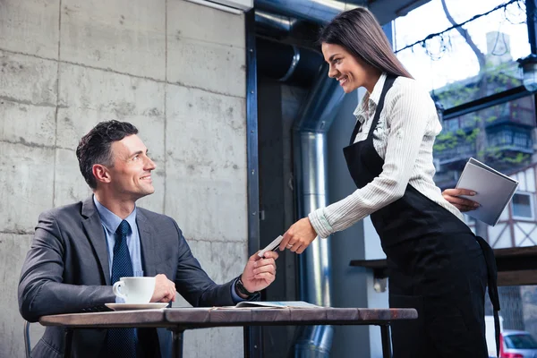 Man giving bank card to female waiter — Stock Photo, Image