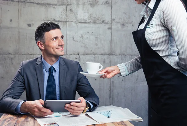 Waitress giving cup with coffee to man — Stock Photo, Image