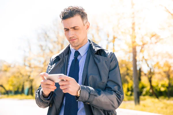 Vertrouwen zakenman gebruikend smartphone — Stockfoto