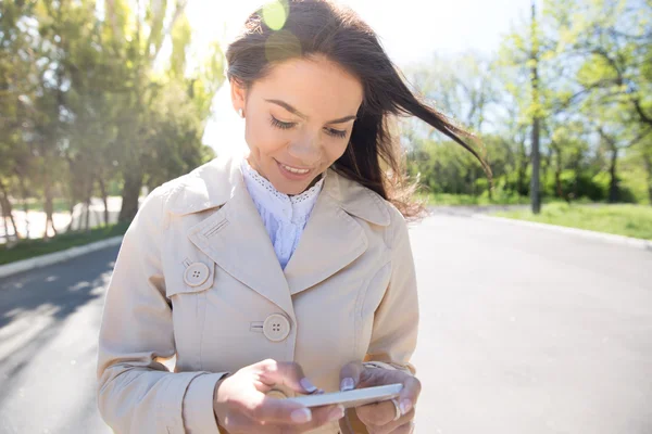 Leende kvinna som använder smartphone — Stockfoto