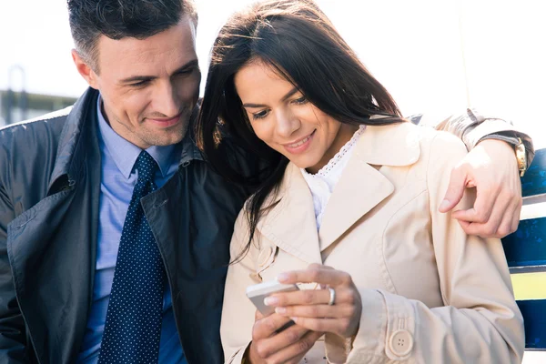 Pareja feliz usando smartphone juntos — Foto de Stock